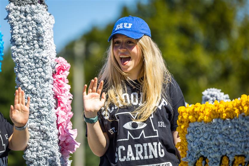 A student rides on a homecoming float